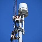 Crew members preparing to lower the cylindrical radar to replace it with a newer version this morning outside the Emergency Operations Center in Bunnell. (© FlaglerLive)