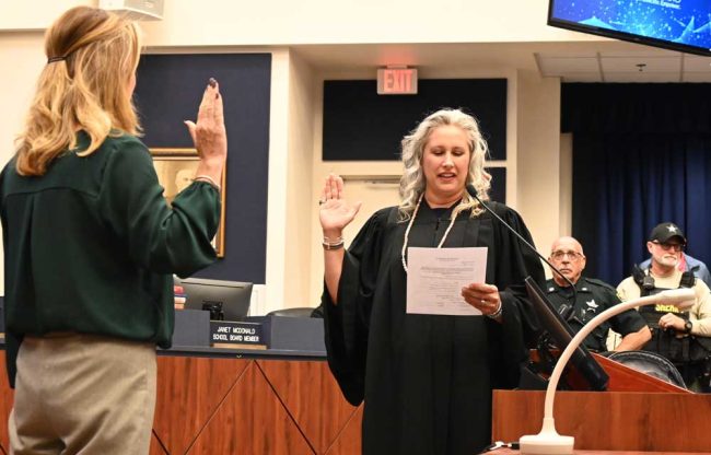 Judge Melissa Distler administering the oath of office to a school board candidate a few years ago. (© FlaglerLive)