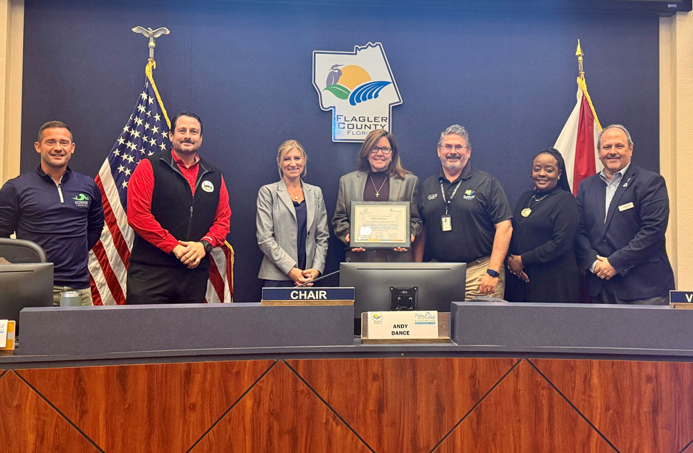 Debra Morgan, center, with members of the Tourist Development Council. From left, Oceanside Bar and Grill co-owner John Lulgjuraj, Flagler Beach Commissioner Eric Cooley,