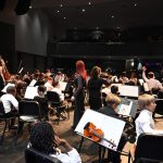 Ms. Cheryl, center, in the 50th and last concert of the Flagler Youth Orchestra at the Flagler Auditorium in May. (© FlaglerLive)
