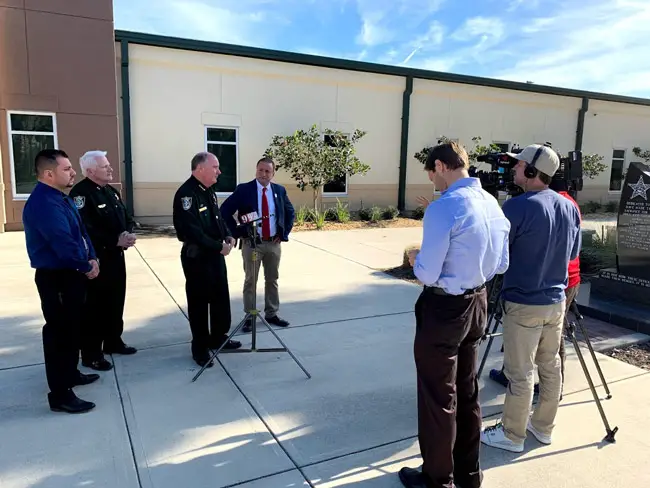 County Commissioner Joe Mullins, center, speaking with reporters outside the Sheriff's Operations Center in Bunnell in January. (© FlaglerLive)