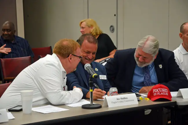 Focus on Mullins: Bunnell City Commissioner John Rogers, left, with County Commissioner Joe Mullins, center, and County Administrator Jerry Camweron this morning before the beginning of the Public Safety Coordinating Council meeting. (© FlaglerLive)
