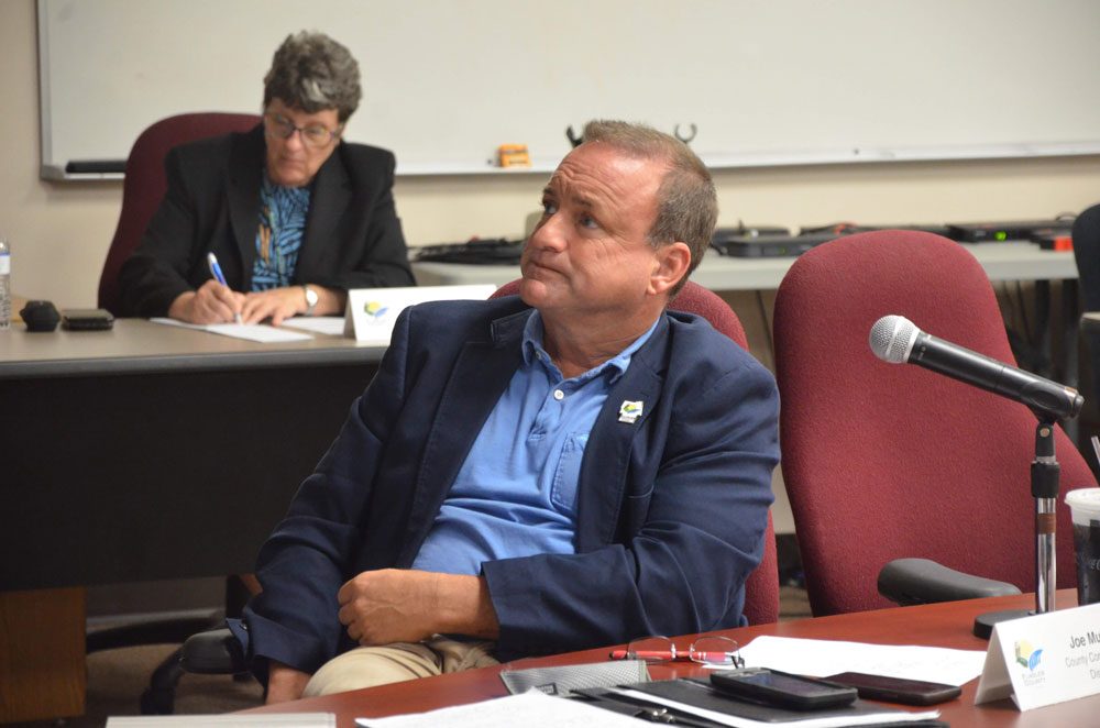 County Commissioner Joe Mullins had County PIO Julie Murphy, in the background, write a press release about a donation he made to an addiction-recovery program in Bunnell. What followed exposed a series of issues between commissioners and within county government.