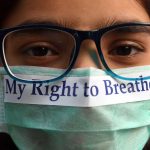 A young protester in India makes a statement about dangerous levels of air pollution.