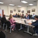 The negotiating table Friday. The county team included, from left, Growth Management Director Adam Mengel, Deputy County Administrator Percy Sayles, County Administrator Heidi Petito and, on the laptop, County Attorney Michael Rodriguez. The Flagler Beach team consisted of City Manager Dale Martin and City Attorney Drew Smith. (© FlaglerLive)