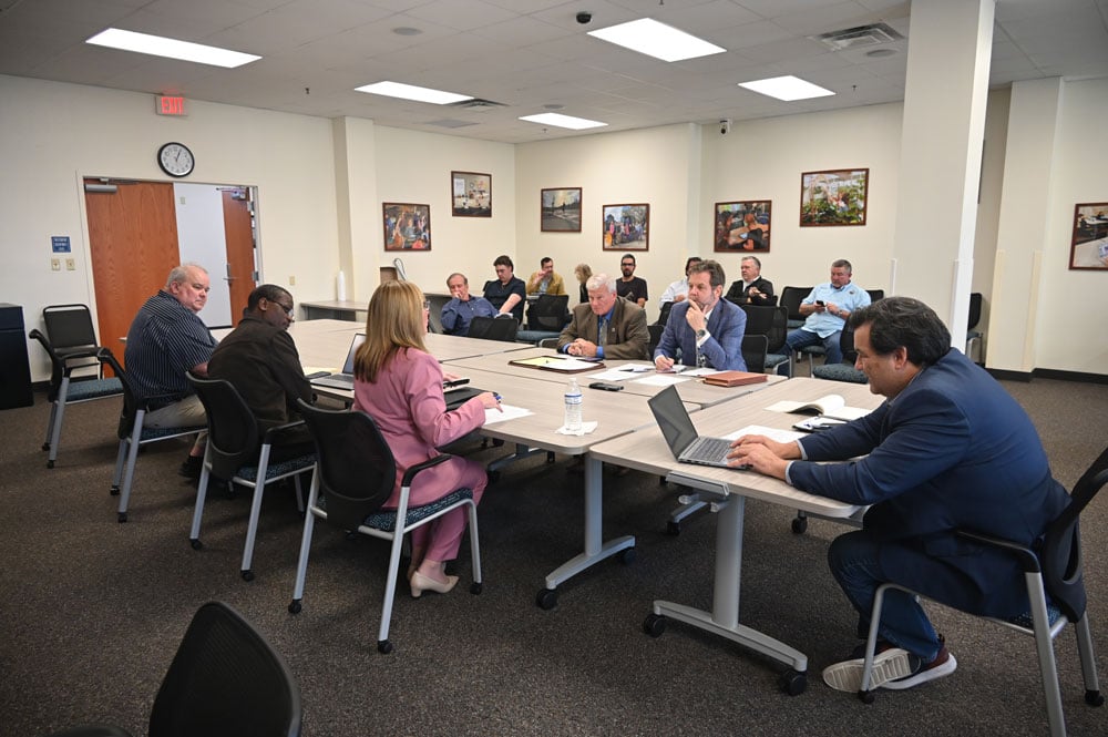 The negotiating table Friday. The county team included, from left, Growth Management Director Adam Mengel, Deputy County Administrator Percy Sayles, County Administrator Heidi Petito and, on the laptop, County Attorney Michael Rodriguez. The Flagler Beach team consisted of City Manager Dale Martin and City Attorney Drew Smith. (© FlaglerLive)