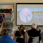 A memorial for former Palm Coast Mayor Jon Netts earlier this year sharpened the sense that the city was heading toward a fork in its direction, possibly a distance away from the direction Netts and his follower, Milissa Holland, at the podium, set. (© FlaglerLive)
