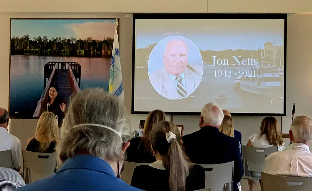 A memorial for former Palm Coast Mayor Jon Netts earlier this year sharpened the sense that the city was heading toward a fork in its direction, possibly a distance away from the direction Netts and his follower, Milissa Holland, at the podium, set. (© FlaglerLive)