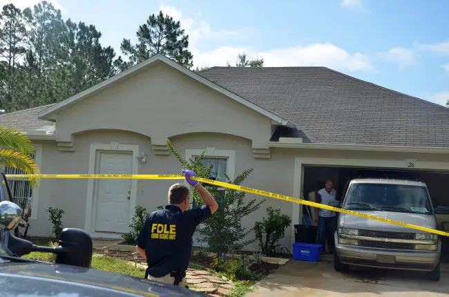 A state crime scene investigator and a medical examiner staffer Sunday morning as they were preparing to remove Leonard Lynn's body, three and a half days after the killing. Click on the image for larger view. (© FlaglerLive)