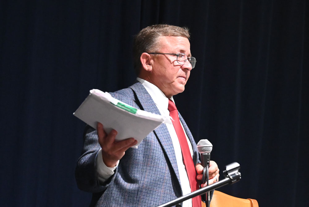 Mike Norris with a copy of the ethics complaint against him as he addressed his town hall crowd about it on Monday, saying it had been dismissed. (© FlaglerLive)