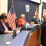 The commissioners sign their oath of office before Judge Melissa Distler. From left, Pam Richardson, Kim Carney and Andy Dance. Leann Pennington is behind the judge. (© FlaglerLive)