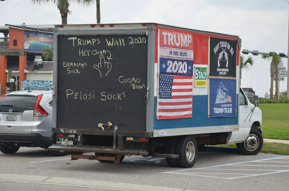The mastodon truck now bearing much more offensive signs, when it was a bit more po9lite last November, parked at one of its favorite  spots: Veterans Park in Flagler Beach. (© FlaglerLive)