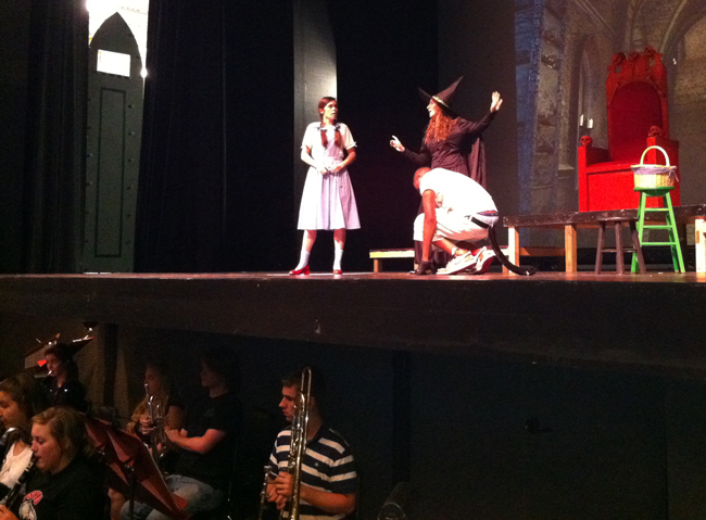 Dorothy (Caitlin Hannan), in a rehearsal at the Flagler Auditorium, with the Wiocked Witch (Leana Gardella) and the King of the Flying Monkeys (Patrick Farris). (© FlaglerLive)