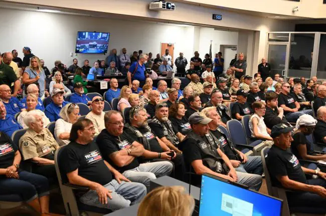The sheriff's police union had distributed t-shirts before the meeting, and hundreds of sheriff's employees and supporters filled every seat and crowded the back of the room, spilling into the hallway at the County Commission meeting Monday evening. (© FlaglerLive)