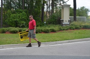 A Palm Coast Code Enforcement officer removed one of Supervisor of Elections Kimberle Weeks's signs about today's vote from a right-of-way near Town Center. The officer'[s pick-up truck was full of such signs. Click on the image for larger view. (© FlaglerLive)