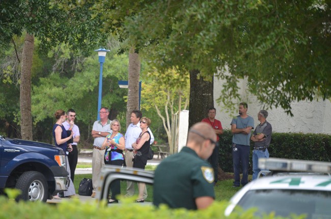 Some of Palm Coast Data's personnel stood by outside the building as the hazmat team worked. (© FlaglerLive)