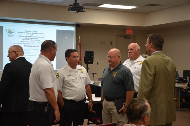 The principals in the proposed transfer of the Bunnell Fire Department to Flagler County's jurisdiction. From left, with his back to the camera, Bunnell City Commissioner John Sowell, Flagler County Fire Rescue's Joe King, Fire Chief Don Petito, Firefighters' union chief Stephen Palmer, who supports the merger, Bunnell Fire Chief Ron Bolser, and County Administrator Craig Coffey. (c FlaglerLive)