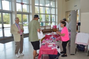 Left, Tony Papandrea, board chairman of the Florida Hospital Foundation, near a stand with Pink Army goodies this morning at the Government Services Building. (c FlaglerLive)