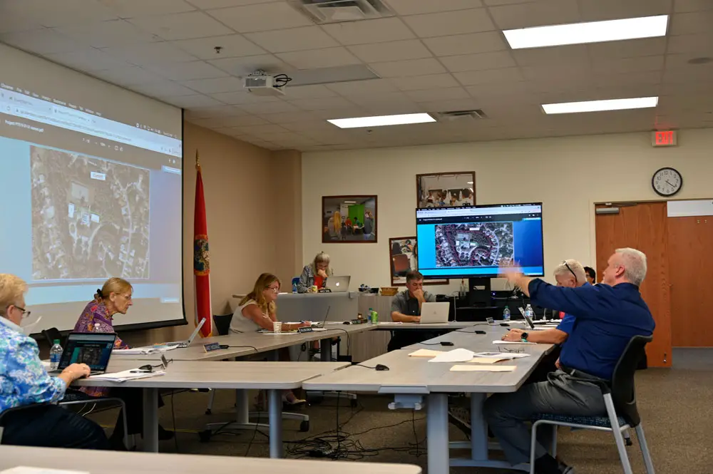 Assistant Superintendent Paul Peacock, right, outlines a plan to remake the Belle Terre Swim and Racket Club as a school site that would accommodate several district programs while possibly still preserving some of the club's amenities. The board members studied their options. (© FlaglerLive)