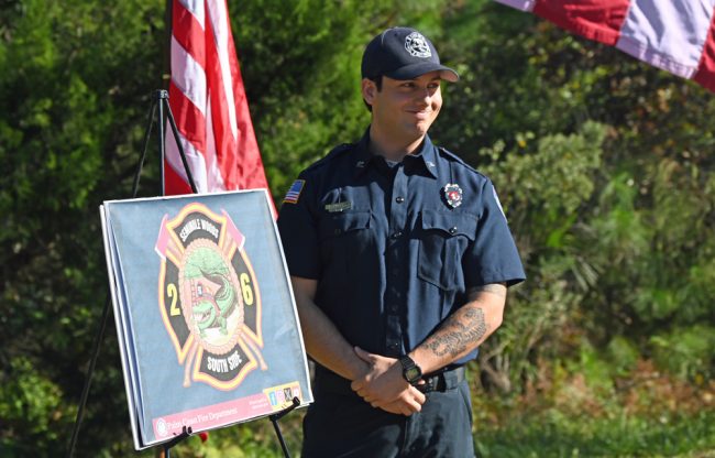 Firefighter Gunner Pemberton with the logo he designed for the new fire station. (© FlaglerLive)