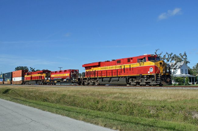 A Bob Pickering photo of a Florida East Coast train passing through Bunnell, on Rail Street, where Pickering noted in his original posting of the image that ' The home in the background is over 100 years old.' We've featured that house here before. The train, Pickering wrote, was 'hard at work bringing 'stuff' to Miami' the day before Thanksgiving. Click on the image for larger view. (© Bob Pickering)