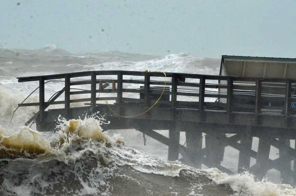 The Flagler Beach pier, battered but still standing, if inaccessibly so, during Hurricane Nicole's worst. (© FlaglerLive)
