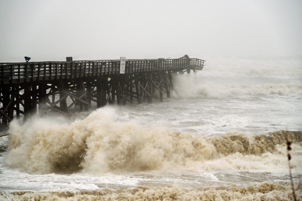 The Flagler Beach pier at sundown this evening was continuing to take a pounding from high waves as Hurricane Ian paralleled Flagler's shore. (© FlaglerLive)