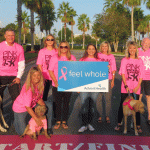 The Pink Army 5K committee, and a few friends, stand at the 5K start/finish line in front of AdventHealth Palm Coast.