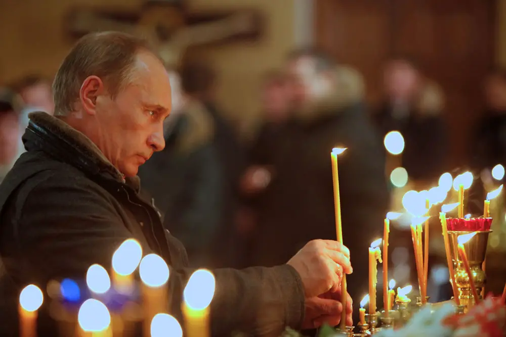 Vladimir Putin lights a candle as he attends an Orthodox Church service in 2011. 