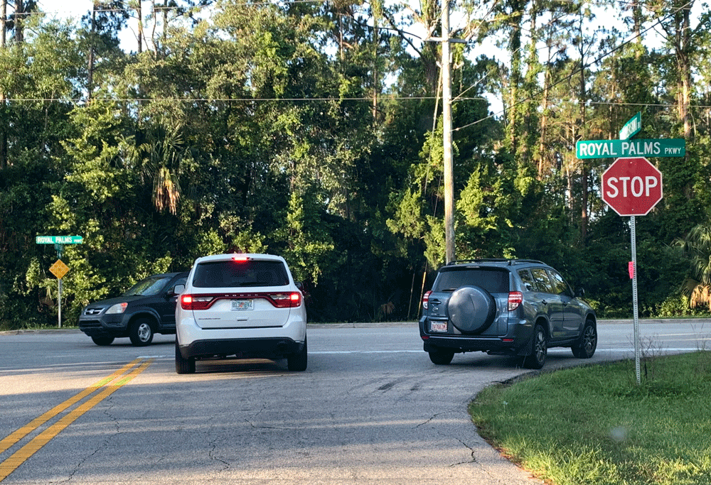 The search for an alleged car-jacker focused on a quadrant immediately northeast of the area of Point Pleasant Drive and Royal Palms Parkway, where the man was apprehended early this morning. Early morning traffic, above, was as brisk as usual even within 45 minutes of an AlertFlagler notice about the armed car-jacker in the neighborhood. (© FlaglerLive)
