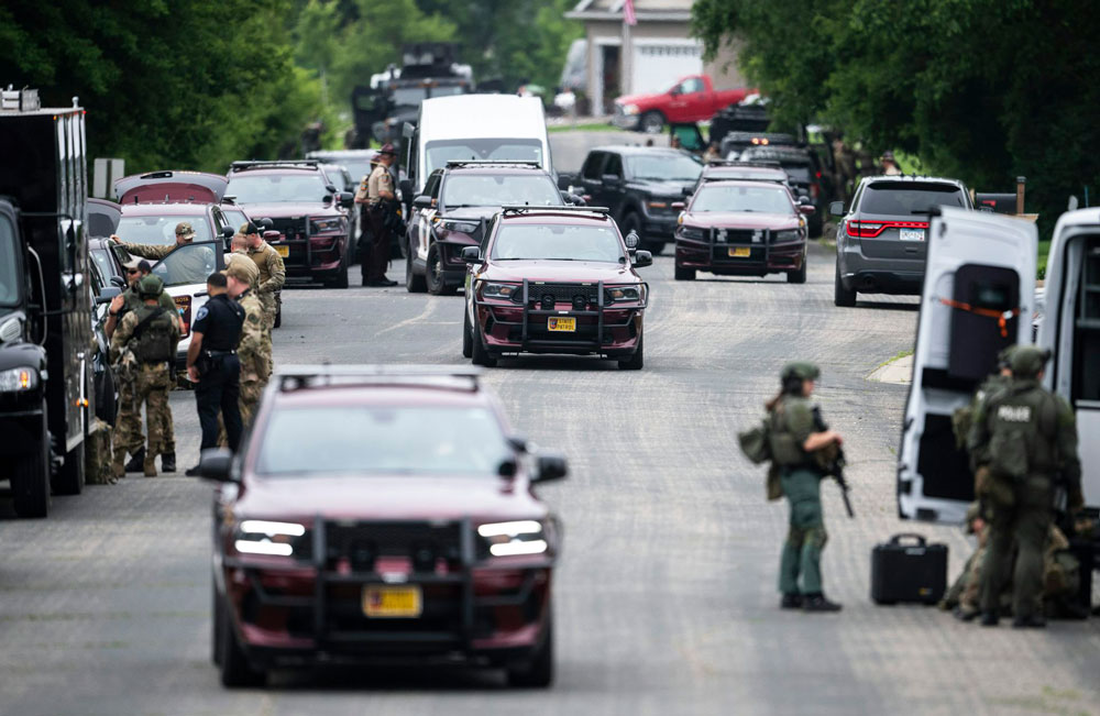Law enforcement set up in Green Isle, Minn., on June 15, 2025, as they search for a suspect in the killing of state Rep. Melissa Hortman and her husband, Mark.