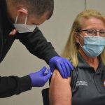 Caryn Prather, Flagler County Fire Rescue's Community Paramedic and one of the leaders of the county's 10-months-long Covid-testing program, getting her first dose of the Moderna vaccine on Tuesday at the Emergency Operations Center. She was one of about 20 people inoculated. (© FlaglerLive)