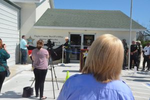 The sheriff unveils the station's new name with  Jason Prather, Grady's son and a sheriff's deputy, as Caryn Prather looks on. (© FlaglerLive)