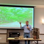 Palm Coast City Historian Preston Zepp showing a glass insulator recovered in the historical resources-rich area west of U.S. 1 during a May lecture on the history of the acreage now slated for Raydient's development. (© FlaglerLive)