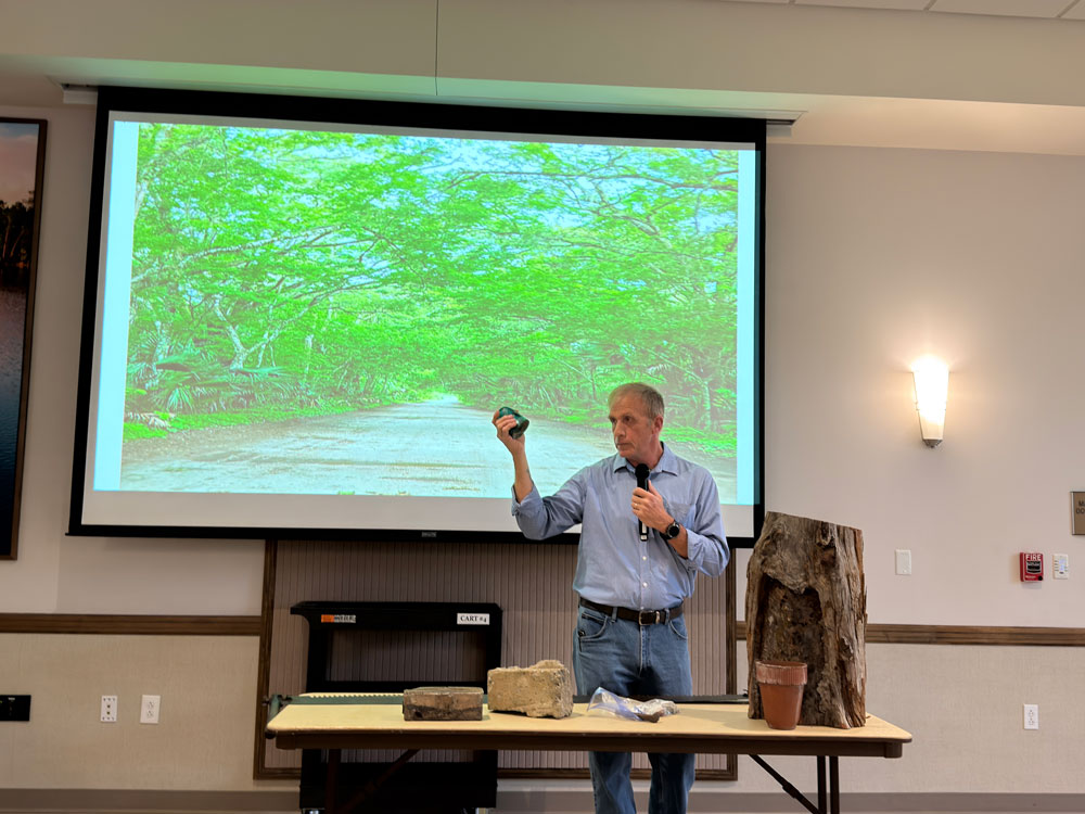 Palm Coast City Historian Preston Zepp showing a glass insulator recovered in the historical resources-rich area west of U.S. 1 during a May lecture on the history of the acreage now slated for Raydient's development. (© FlaglerLive)