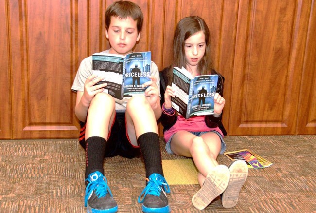 Nathan and Brooklyn Warner, attending the Wittman event with their grandfather Bob Pearson of Palm Coast, got a sneak preview of Wittman's book in the Auditorium lobby. (Skip Westhall)