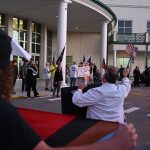 Students and parents protesting against a potential book ban in school libraries were confronted with a loose band of counter-protesters at the Government Services Building Tuesday evening, some of them in camouflage, taunting the students and parents with obscenities. (© FlaglerLive)