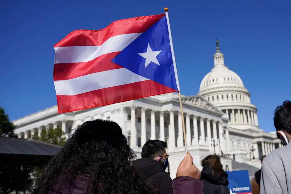 A woman waves a Puerto Rico flag to support Puerto Rican statehood on March 2, 2021. (AP Photo/Patrick Semansky)