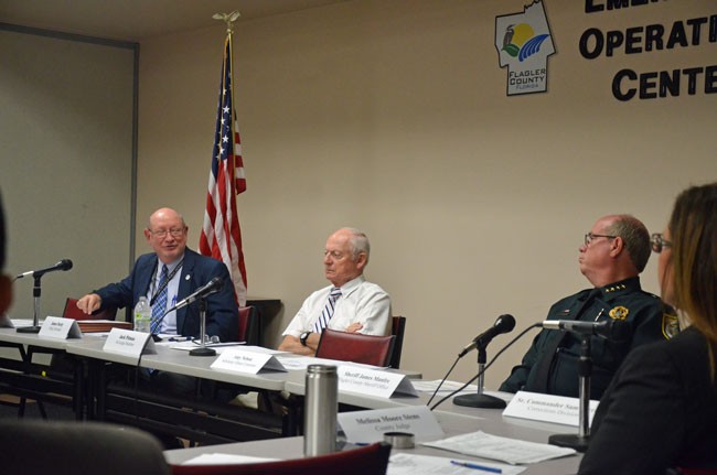 Public Defender James Purdy, left, cautioned that while cops' body cameras are a very good thing, they are creating a woprkload neither his office nor the state attorney's office can shoulder with existing staff. Sheriff Jim Manfre, right, defended the use of the cameras, which are worn by every deputy in Flagler--one of the few Florida police agencies where the cameras are widely in use. Jack Pitman, an at-large member of the Public Safety Coordinating Council, where the discussion took place, is in the crossfire. (© FlaglerLive)