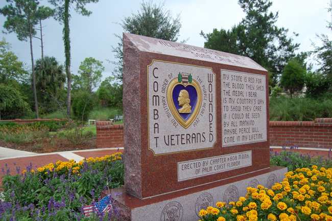 Today is Purple Heart Day. The medal has been awarded to some 1.7 million members of the U.S. military who have sustained wounds or been killed in combat. The Flagler County Commission proclaimed today Purple Heart day at its meeting on MOnday. Above, the Purple Heart monument installed at Heroes Park in Palm Coast by the Palm Coast chapter of the Military Order of the Purple Heart—Chapter 808, in 2010. (© FlaglerLive)