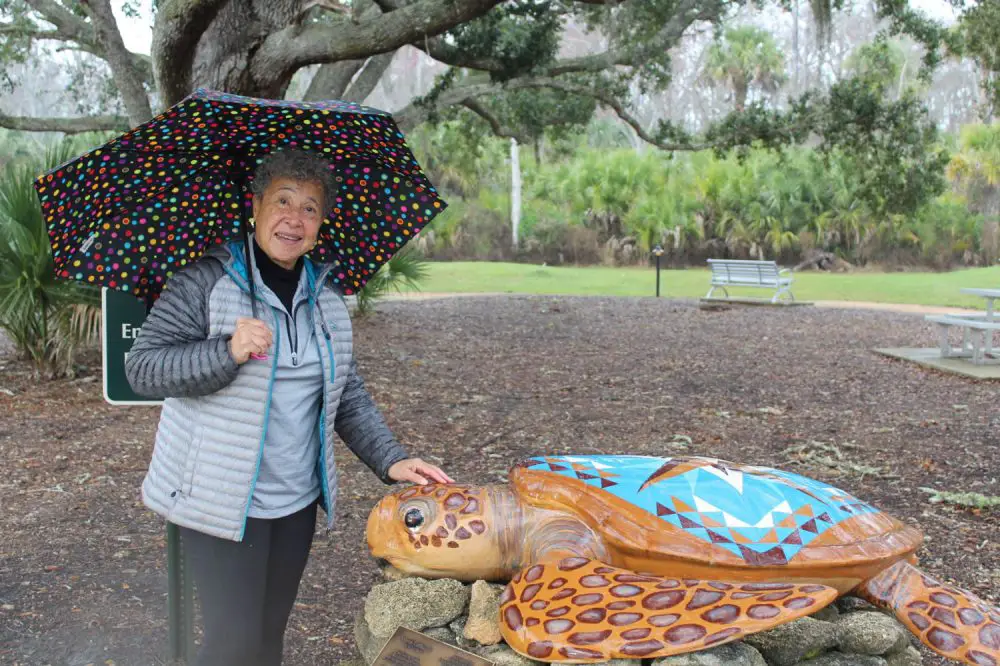 Artist Betty Eubanks with "Quilty," the sixth sculpture in the Palm Coast Arts Foundation's Turtle Trail, when Quilty was installed at Waterfront Park in 2019. See additional pictures of the turtle below. (PCAF)