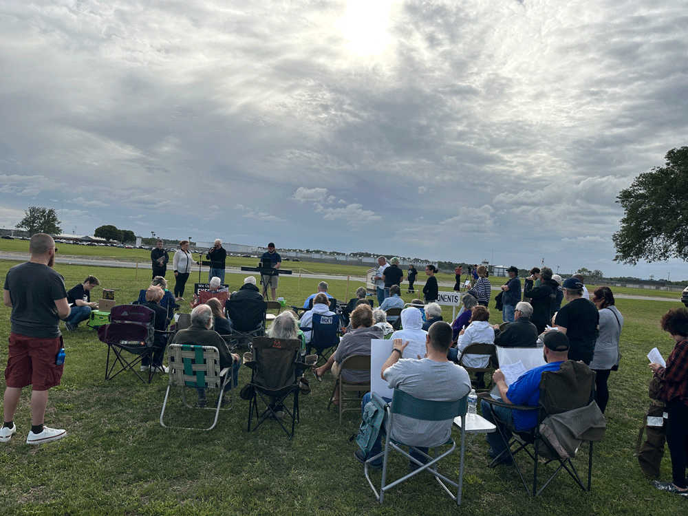 Moments before Louis Gaskin was put to death by lethal injection in the state prison, in the background, a group of opponents of the death penalty from Volusia and Flagler counties held a service led by Father Phil Egitto. He has been leading services across the road from the prison at every execution for a decade and a half. (© FlaglerLive)