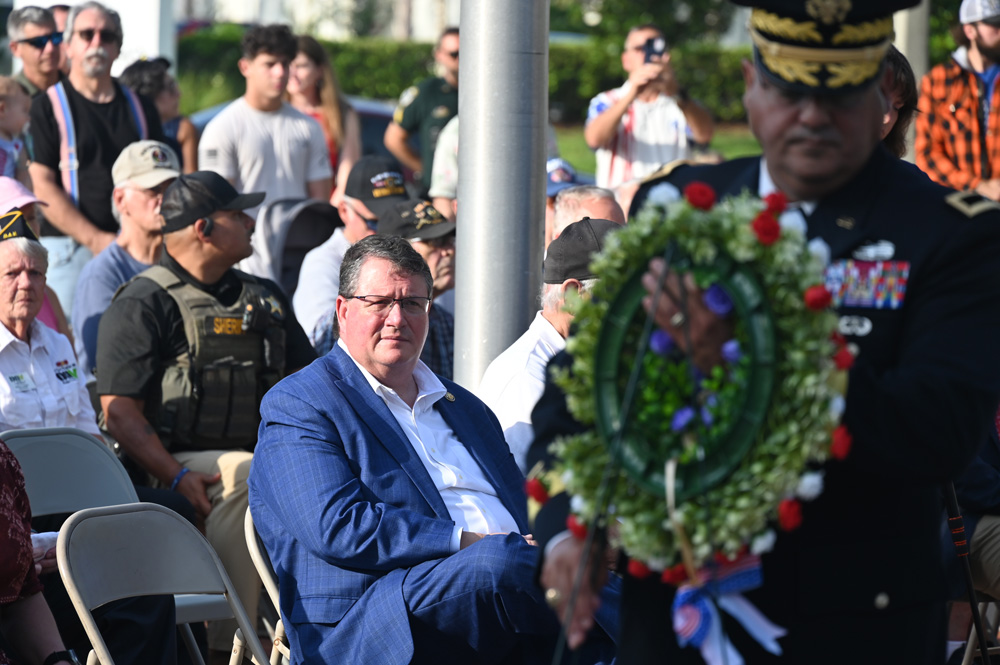 U.S. Rep. Randy Fine, left, as Palm Coast Council member Charles Gambaro would ceremonially place a wreath near a monument during Monday's Memorial Day commemoration at Heroes Park. (© FlaglerLive)