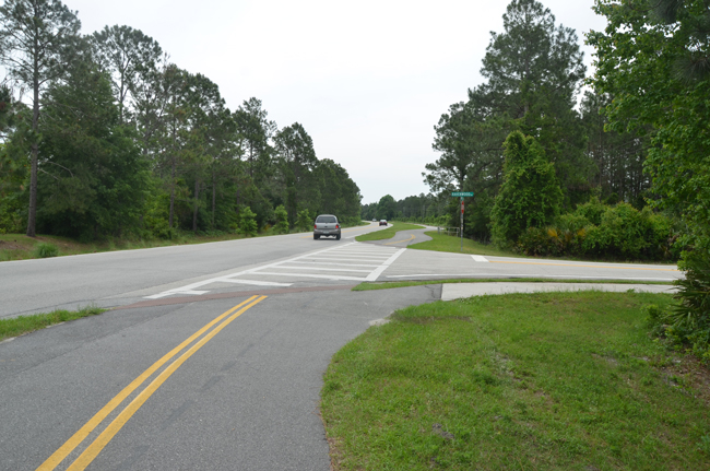 Janet Schutte, 77, was struck by an SUV as she was cycling across Ravenwood Drive, going west on White View Parkway, The cars shown here are traveling east on White View. (© FlaglerLive)