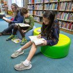 Children and an adult read books at the Altadena Main Library in Altadena, Calif., in March 2025.