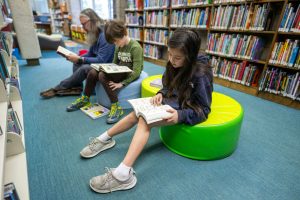 Children and an adult read books at the Altadena Main Library in Altadena, Calif., in March 2025.