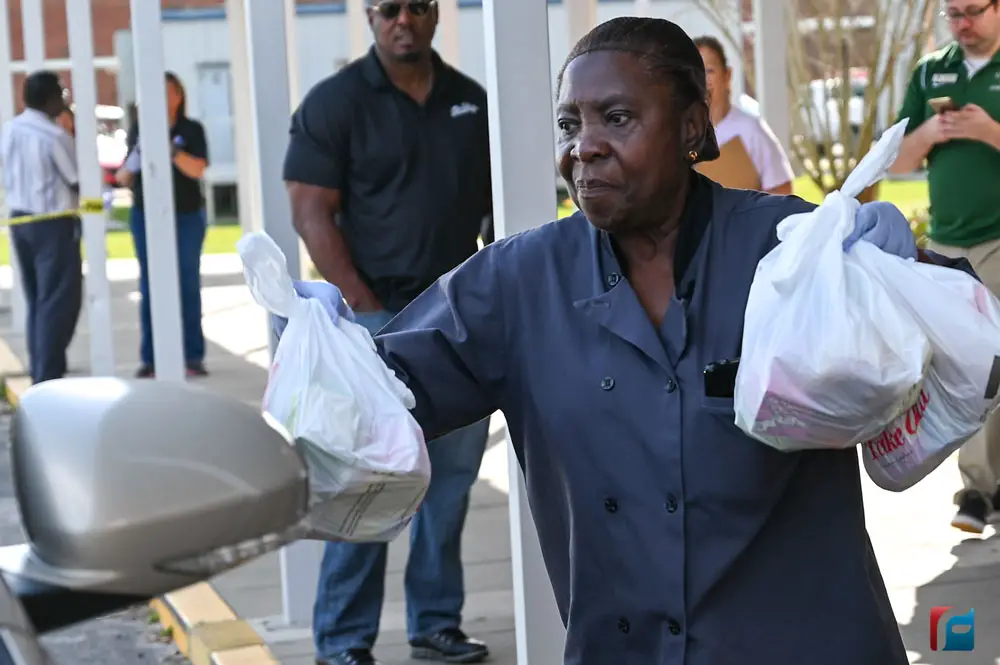 Louise McCourty, a Flagler Palm Coast High School employee, distributing meals today at the school to families with children 18 and younger. (Flagler Schools). 