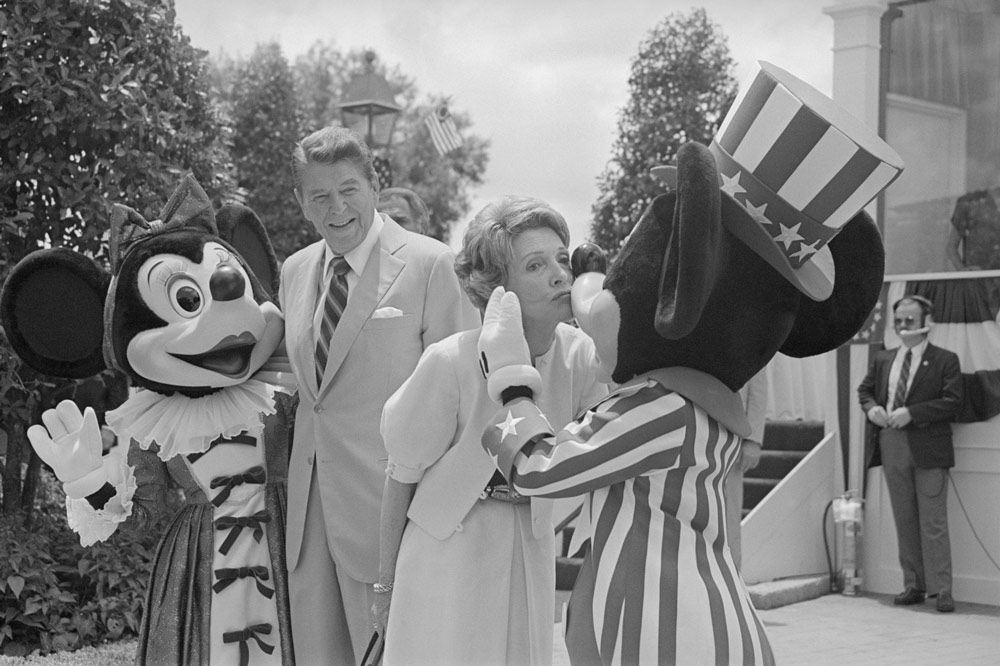 First lady Nancy Reagan kisses Mickey Mouse as President Ronald Reagan and Minnie Mouse watch 20 bands marching in the unofficial inaugural parade at Disney’s Epcot Center on Memorial Day, May 27, 1985.