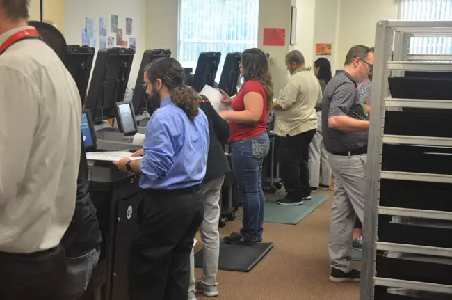 Flagler Elections Supervisor workers feeding ballots into precinct-level tabulators Sunday during an all-day recount. (© FlaglerLive)
