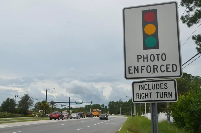 What used to be a sign warning of red-light cameras at Palm Coast's intersection at Belle Terre Parkway and Central Avenue. The cameras were removed last year after a 10-year reign in the city, much of it despised by most, including judges and, finally, by city officials, who elected to end the contract with American Traffic Solutions two years early. (© FlaglerLive)